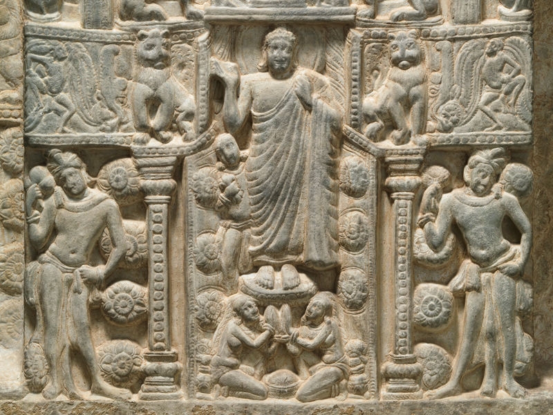 A detail of a limestone drum panel depicting a stupa with the Buddha’s descent from Trayastrimsa Heaven. This panel depicts a grandly decorated stupa with the Buddha at its entrance, his hand raised to grant protection. 